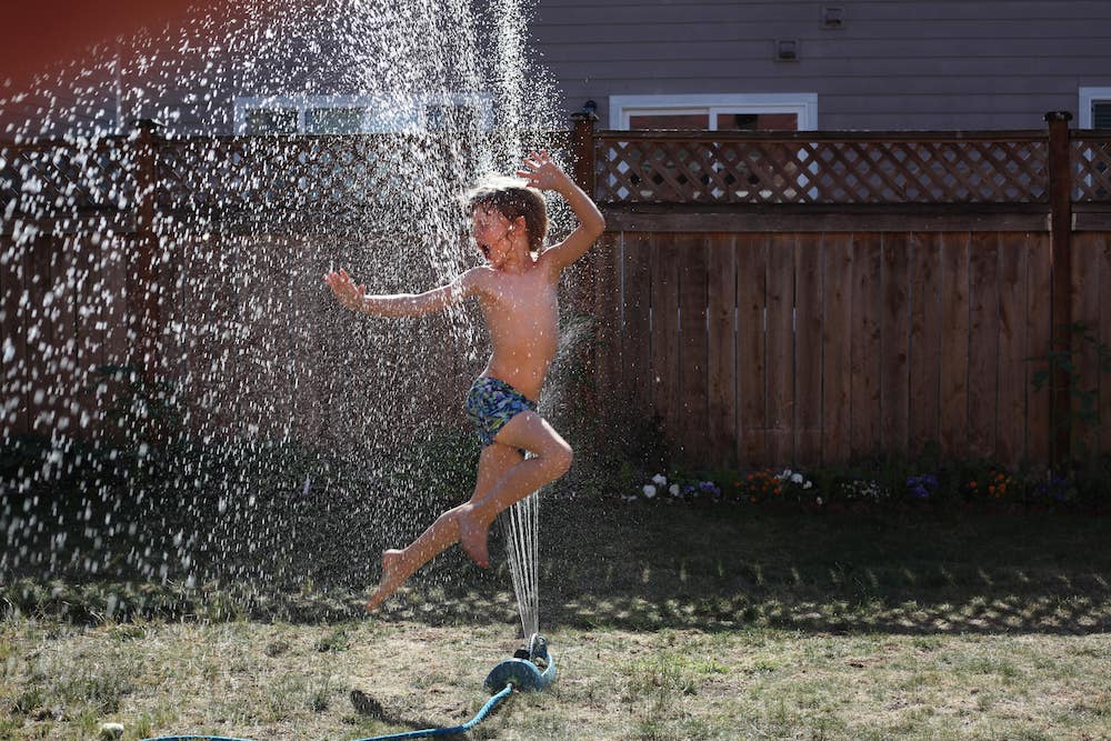 Kid playing in water sprinkler