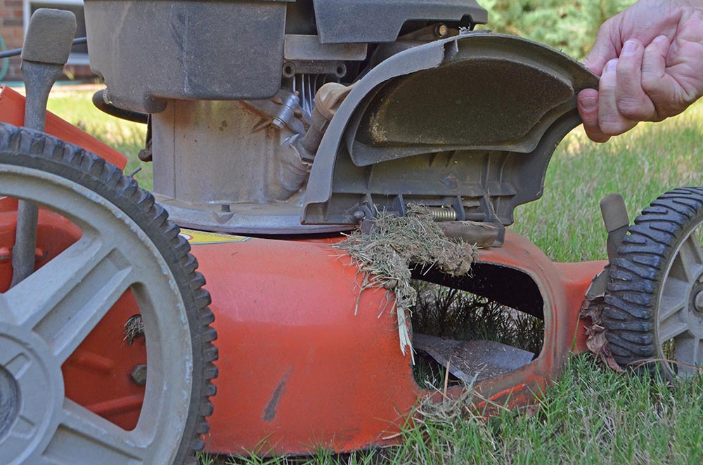 Clean up the mower's deck — the flat cover above the mower blade