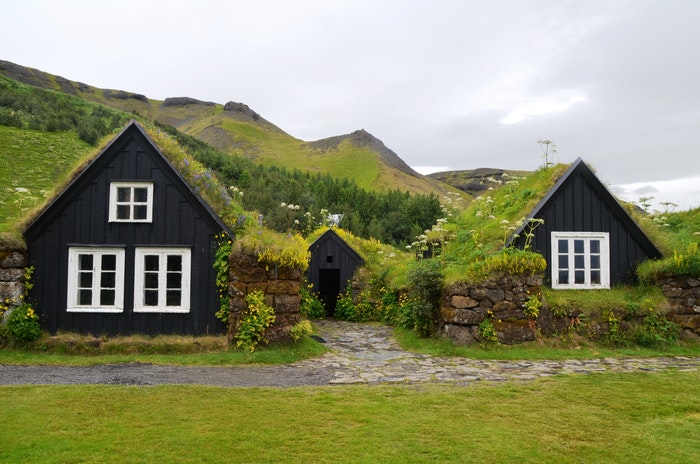 Small black farmhouse against green landscape