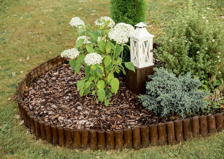 Round flower bed with landscape timbers for edging