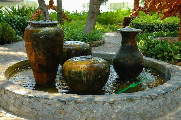 Water fountain with four urns. Two urns are tall and two are short.