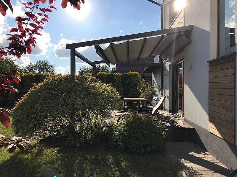 Aluminum pergola with retractable canopy over patio