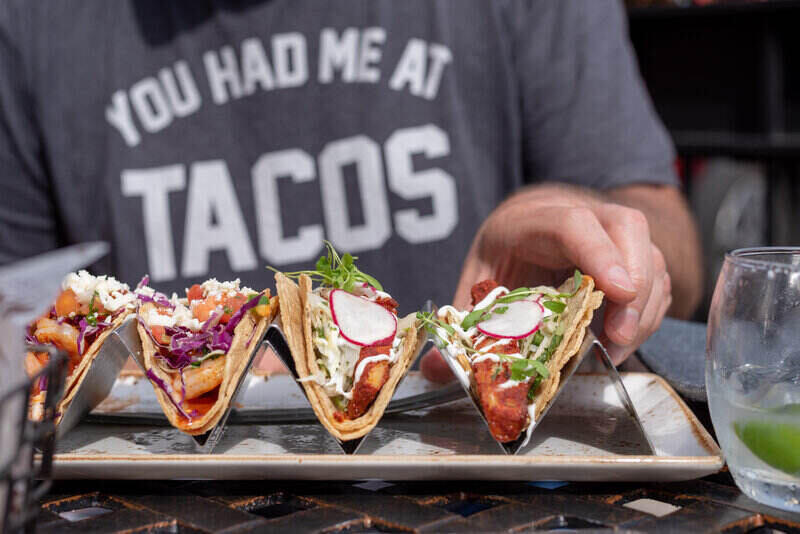 Closeup of man reaching for taco outside in summer