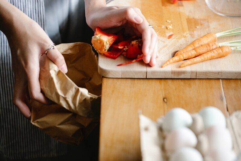 woman cleaning cutting board in a kitchen