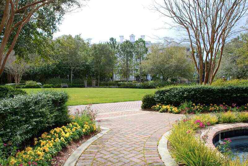 Paver Briks Walkway in the garden with yellow flowers on side