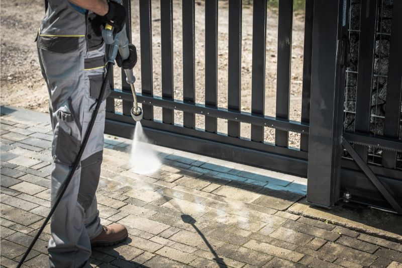a man pressure washing the driveway using a pressure tool