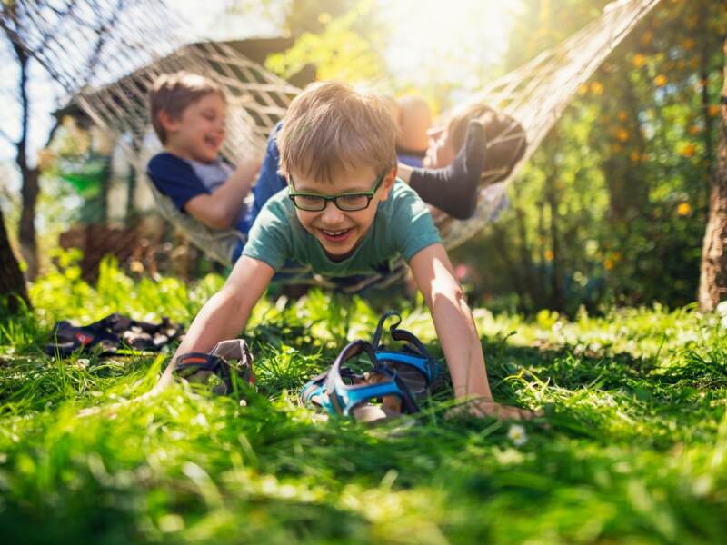 kids playing in a hammock and in the grass