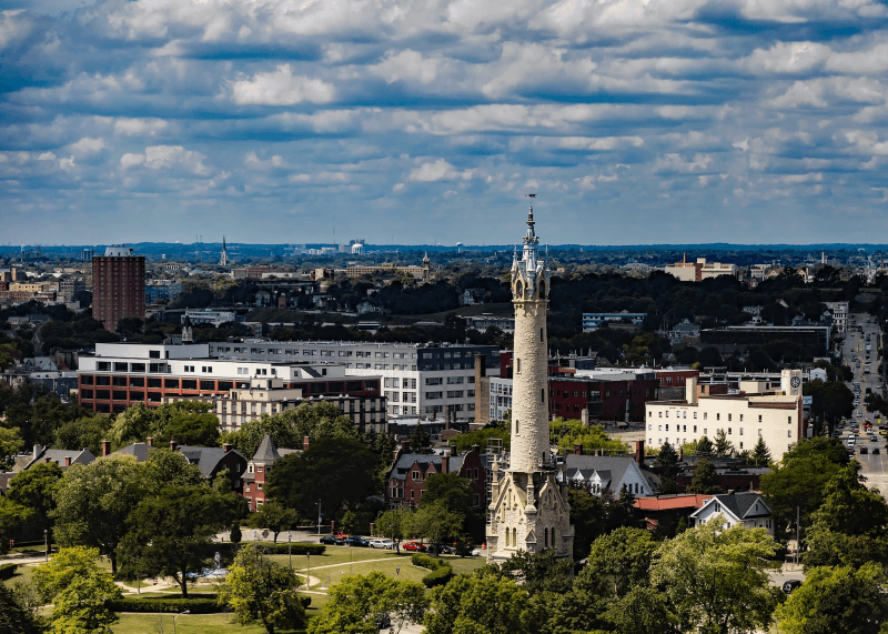 Colorful old buildings, modern high-rises, and unique towers stand out across Milwaukee’s skyline on a semi-cloudy day.