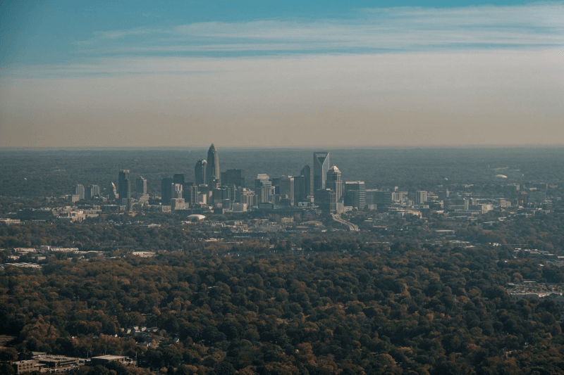 Trees surround the skyline of Charlotte, North Carolina, on a hazy day