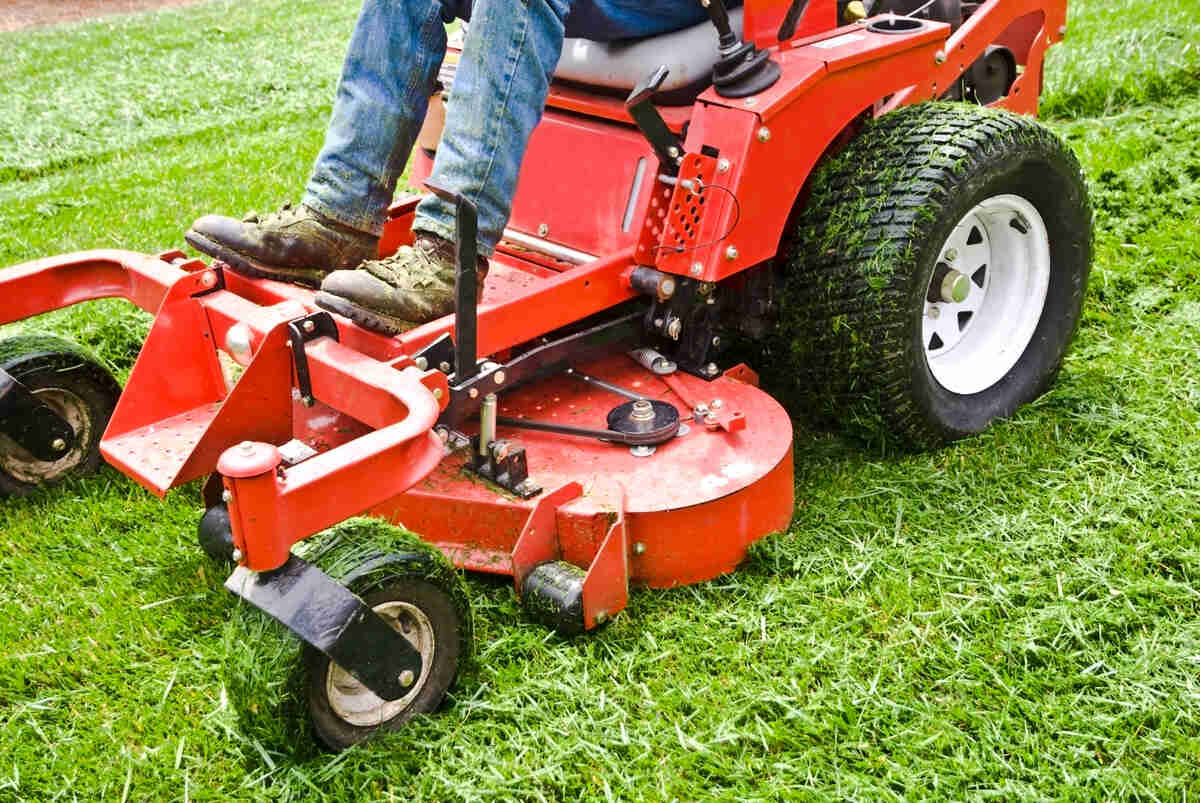 person mowing the lawn using a riding lawn mower