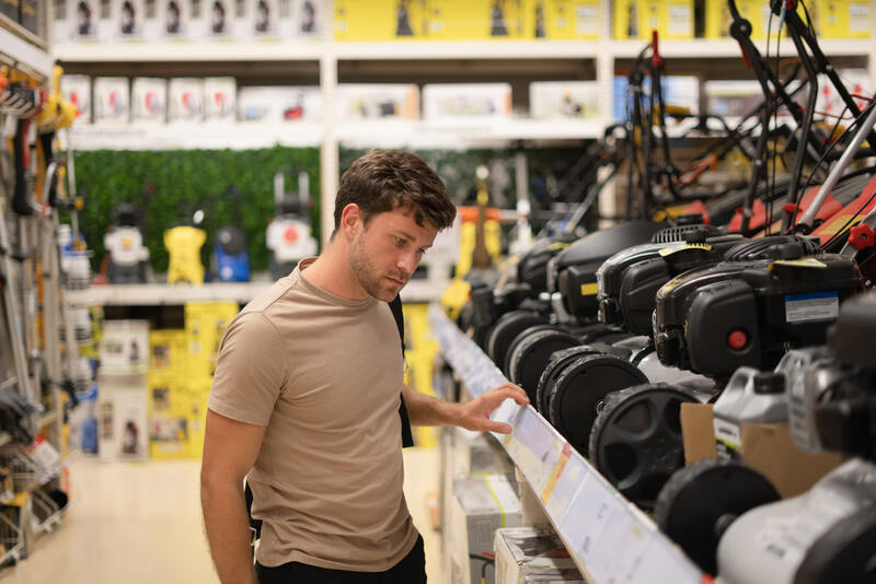 Man in shop with lawn mowers 